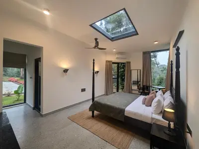 a bedroom with a bed with a skylight at Birdsong Luxury Pool Villa by Luxunlock Private Villas in Suntikoppa