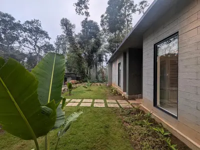 a backyard of a house with a large window at Birdsong Luxury Pool Villa by Luxunlock Private Villas in Suntikoppa