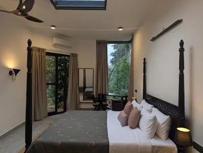 a bedroom with a large bed and a balcony at Birdsong Luxury Pool Villa by Luxunlock Private Villas in Suntikoppa