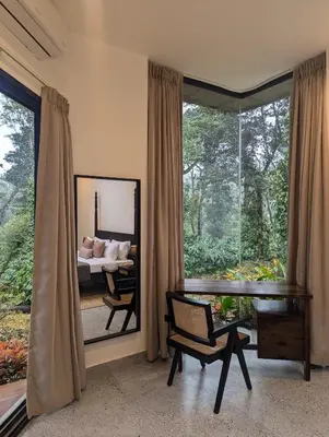 a bedroom with a mirror and a bed and a window at Birdsong Luxury Pool Villa by Luxunlock Private Villas in Suntikoppa