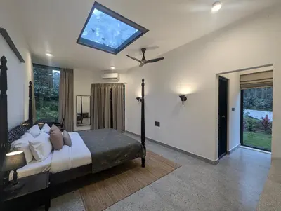 a bedroom with a bed with a ceiling fan at Birdsong Luxury Pool Villa by Luxunlock Private Villas in Suntikoppa