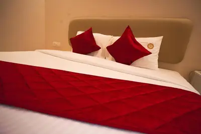 a red and white bed with red pillows on it at RIVERSCAPES by NOORJEHAN in Palakkad