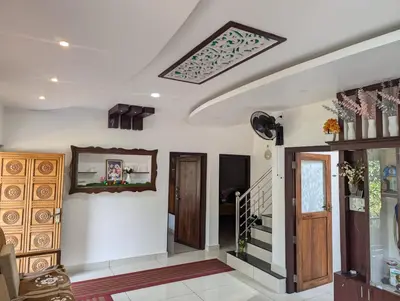 a living room with a skylight and a hallway with stairs at Nadavayal Villa in Wayanad