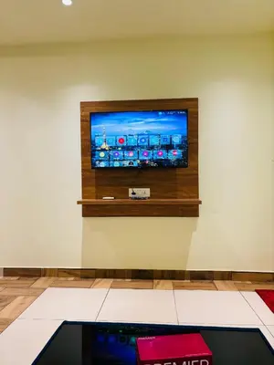 a flat screen tv on a wall at Cous Cous Residency Hotel in Padinjarathara