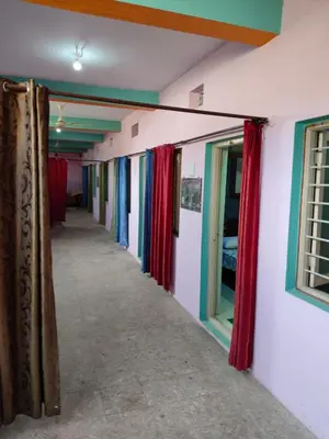 a corridor in a house with curtains on the walls at Sri Vinayaka Tourist Home in Nanjangūd