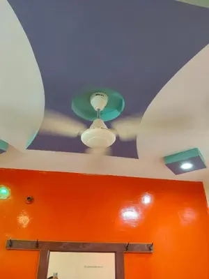 a ceiling with a ceiling fan and an orange wall at Sri Vinayaka Tourist Home in Nanjangūd