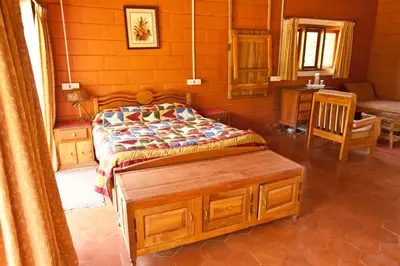 a bedroom with a bed and a table and a chair at Kabbe Hillview Homestay in Madikeri