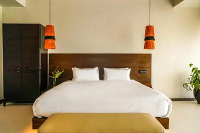 a bedroom with a large white bed with two lamps at Virgin Valley Leisure Resort in Ooty