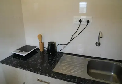 a kitchen counter with a sink and a phone at Perfect Gateway in Mysore