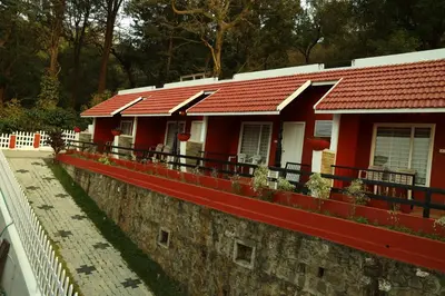 a red house with a red roof on a wall at Velu's Resort in Gūdalūr