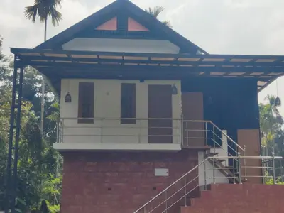 a house with a blue roof and a staircase at Private Cottage Wayanad in Kalpetta