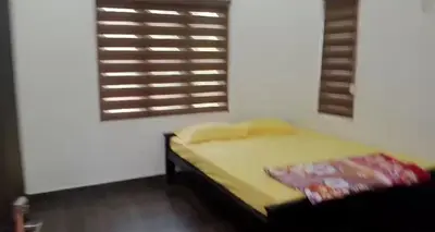 a bedroom with a yellow bed and a window at Private Cottage Wayanad in Kalpetta