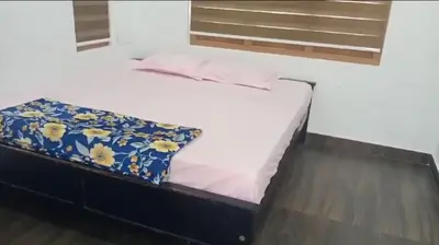 a bed with a blue and white blanket on it at Private Cottage Wayanad in Kalpetta
