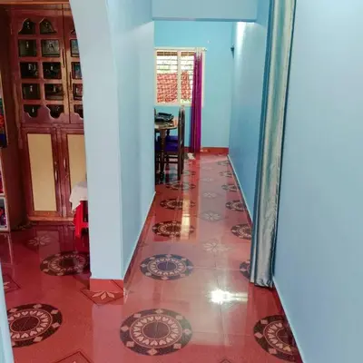 a hallway with a tile floor in a house at Aghasthyashrya Homestay in Siddapur