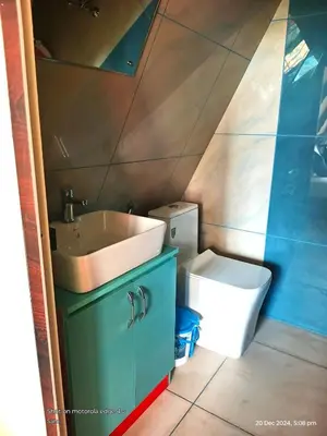 a bathroom with a sink and a toilet at Goldenpeak Estate-Homestay-3Bed-A frame Holiday Home in Wayanad