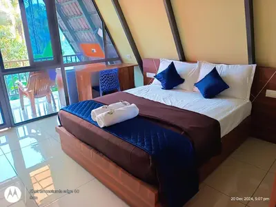 a hotel room with a bed with a purse on it at Goldenpeak Estate-Homestay-3Bed-A frame Holiday Home in Wayanad