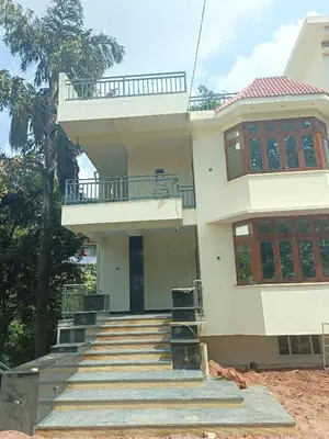 a white house with stairs and a balcony at Ameya Coorg Home Stay in Madikeri