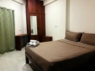 a bedroom with a bed with towels on it at Ameya Coorg Home Stay in Madikeri