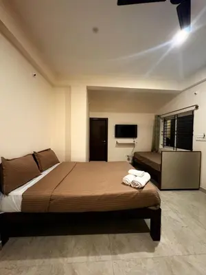 a bedroom with a large bed and a television at Ameya Coorg Home Stay in Madikeri