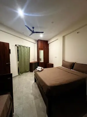 a bedroom with a bed and a ceiling fan at Ameya Coorg Home Stay in Madikeri