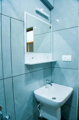 a bathroom with a white sink and a mirror at FLY VIEW Airport Residency in Nedumbassery