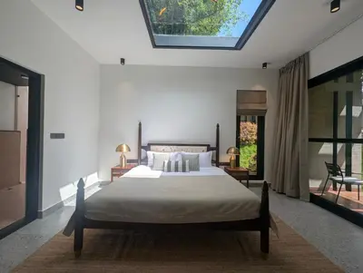 a bedroom with a large bed with a skylight at Earthsong & Birdsong Luxury Pool Villa by Luxunlock Private Villas in Suntikoppa