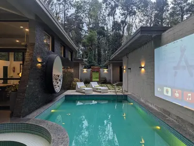 a swimming pool in a house with a projection screen at Earthsong & Birdsong Luxury Pool Villa by Luxunlock Private Villas in Suntikoppa