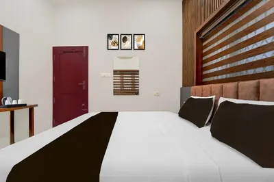 a bedroom with a large bed with a wooden headboard at Townhouse Thondayad Calicut Formerly Dream Casa in Kakkayam