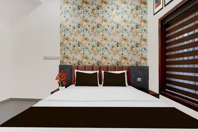 a bedroom with a bed with a floral wall at Townhouse Thondayad Calicut Formerly Dream Casa in Kakkayam
