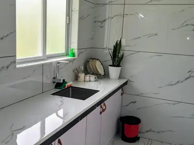a kitchen with white marble walls and a sink at Little home apartment in Kozhikode