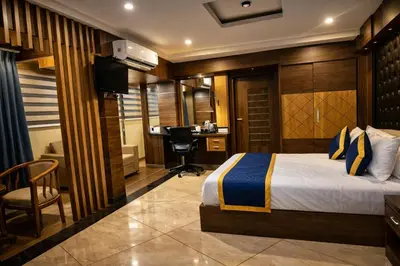 a hotel room with a bed and a desk at Blue Diamond Residency in Perintalmanna