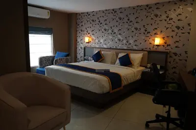 a bedroom with a bed and a chair in a room at Blue Diamond Residency in Perintalmanna