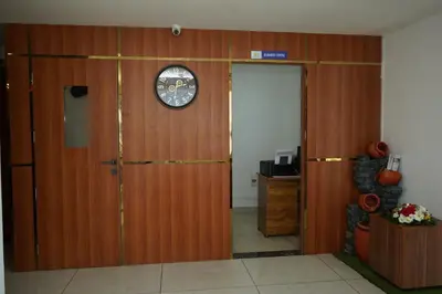 a room with a wooden door with a clock on it at Blue Diamond Residency in Perintalmanna