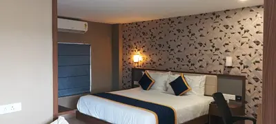 a bedroom with a large bed with a wall at Blue Diamond Residency in Perintalmanna