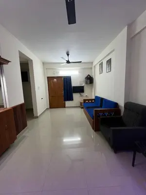 a living room with a couch and a blue couch at 1 BHK flat in Guruvayur - Sooryamadhavam Apartments-only for pilgrims in Guruvāyūr