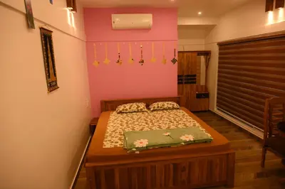 a bedroom with a bed and a pink wall at Sidharth Resort, Vadavannur in Kollengode