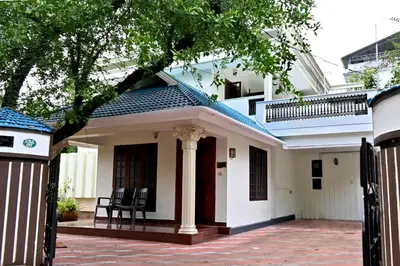 a small white house with a blue roof at Ceema Homestay in Ernakulam