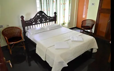 a bedroom with a large bed with two towels on it at Ceema Homestay in Ernakulam