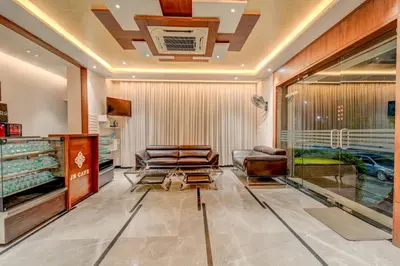 a living room with couches and a tv at Hotel J N Stay Mysore - 12 Minutes to Mysore Palace in Mysore