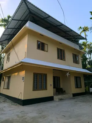 a large yellow house with a lot of windows at Serenity Home Stay in Sultan Bathery