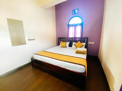 a bedroom with a bed with a purple wall at Hilltown Villa Holiday's in Ooty
