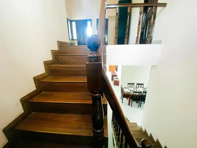 a staircase with wooden steps and a dining room at Hilltown Villa Holiday's in Ooty