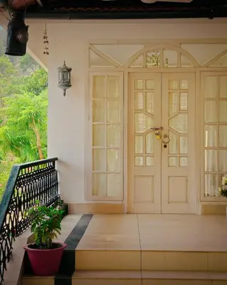 a front door of a house with a potted plant at Vintage Coffee Estate 3 Bedrooms 1 Cottage in Wayanad