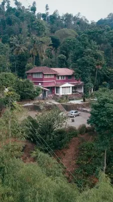 a pink house with a car in a parking lot at Vintage Coffee Estate 3 Bedrooms 1 Cottage in Wayanad