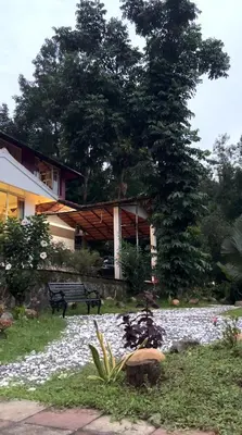 a house with a bench in front of it at Vintage Coffee Estate 3 Bedrooms 1 Cottage in Wayanad