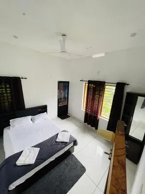 a bedroom with a large bed in a room at aphrodite home stay in Pinangode