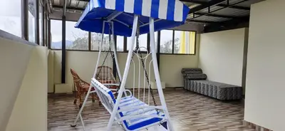 a room with chairs and a blue umbrella at The Monarch in Ooty