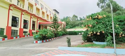 a large building with trees in front of it at The Monarch in Ooty