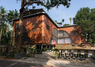 a building with a tree in front of it at Sanketam Motel in Calicut