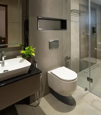 a bathroom with a toilet and a sink and a shower at Sanketam Motel in Calicut